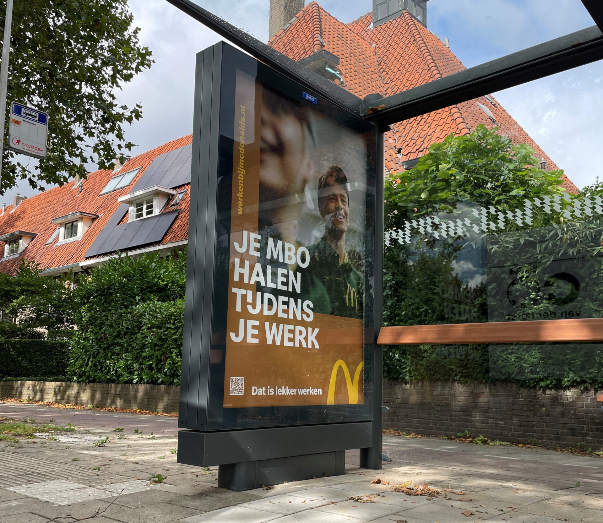 Stevige en flexibele reclameomkasting geplaatst bij een bushalte, geïntegreerd in de omgeving van de openbare ruimte.